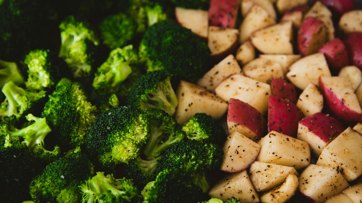 Broccoli and potatoes seasoned and ready to be roasted